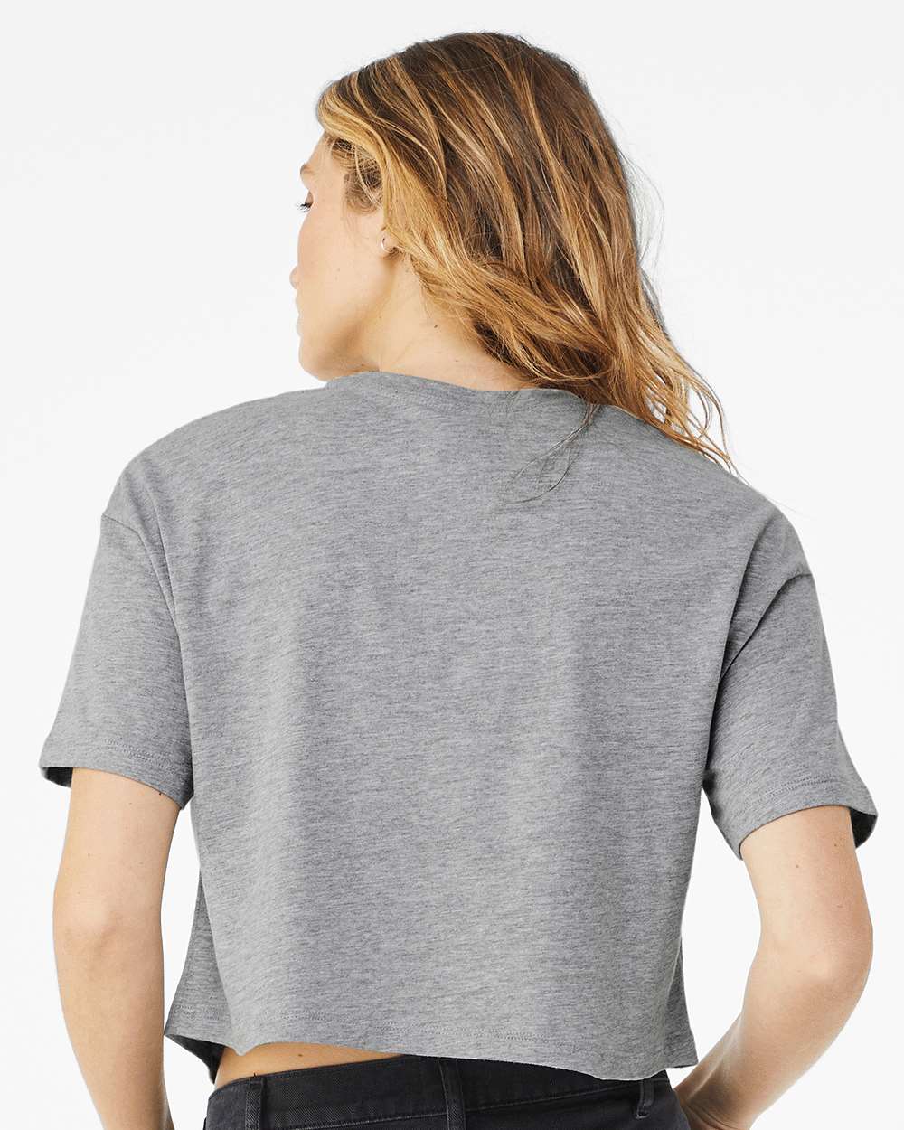 Person wearing a gray crop top on a white background